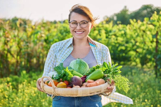 portrait-of-smiling-woman-with-basket-of-different-2024-12-08-02-15-22-utc