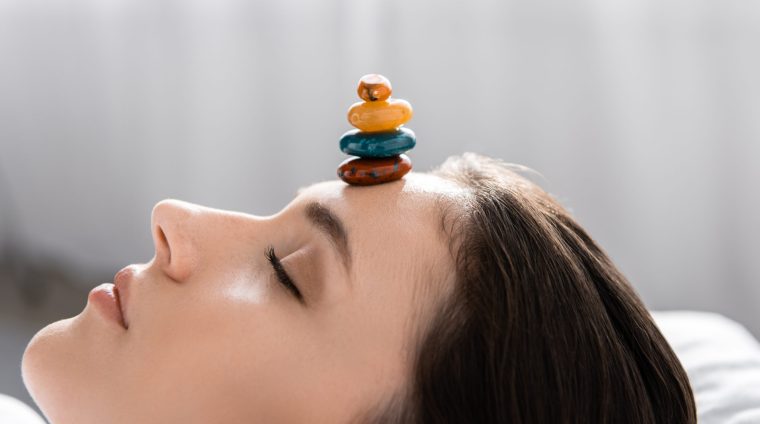 woman-lying-with-closed-eyes-with-colorful-stones-2024-11-17-07-25-23-utc